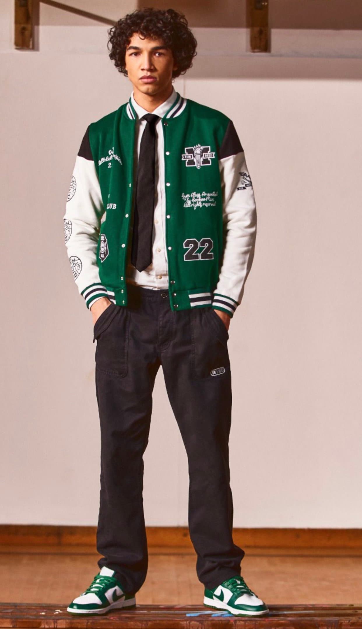 Green varsity jacket and tailored trousers